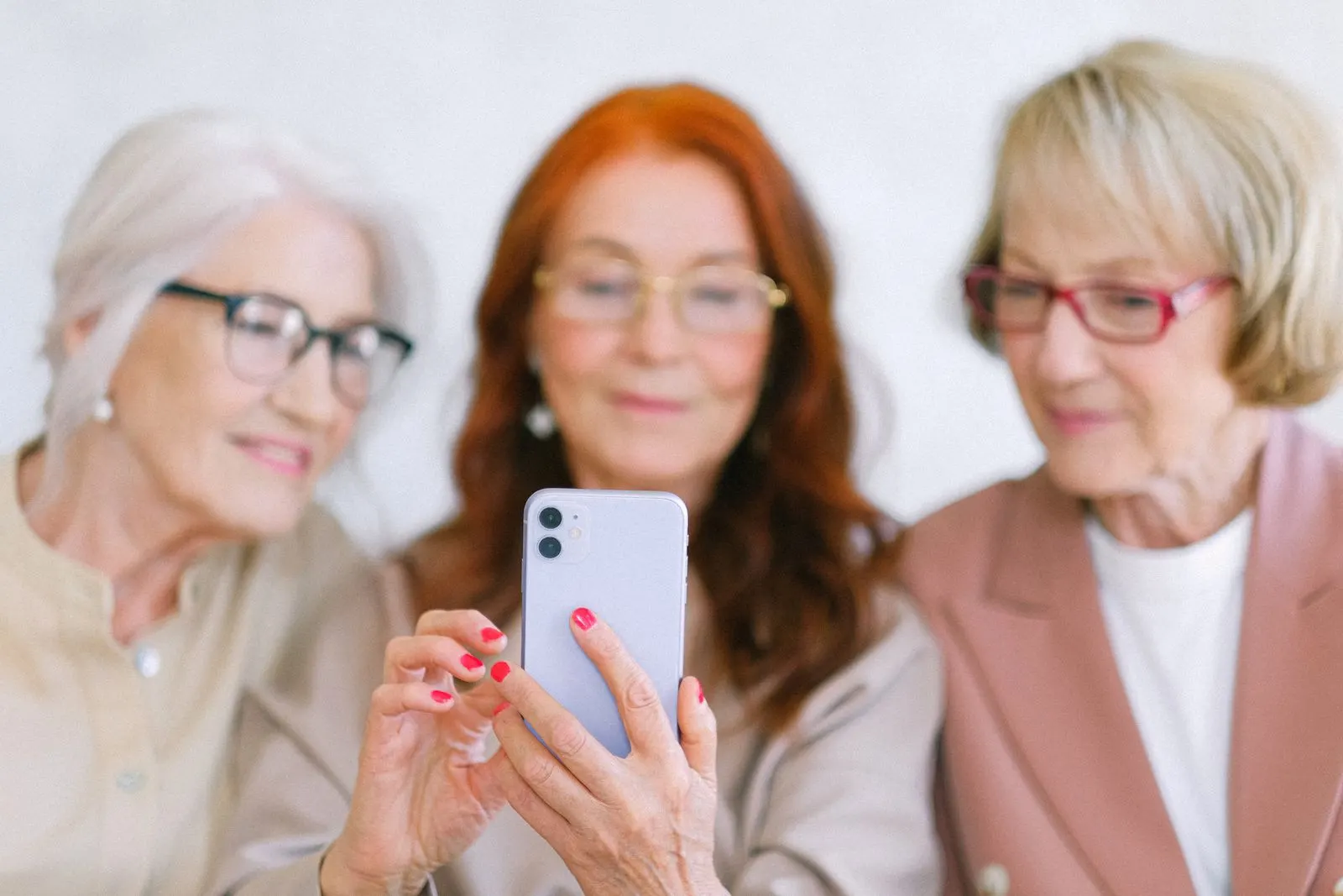 Birlikte akıllı telefon kullanan yaşlı kadınlar; temsili fotoğraf